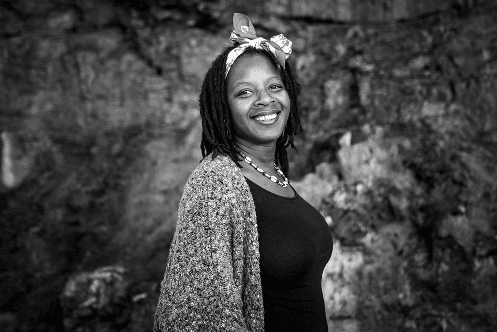 Fayola Edmunds, founder of Belonging Therapy, smiling outdoors.